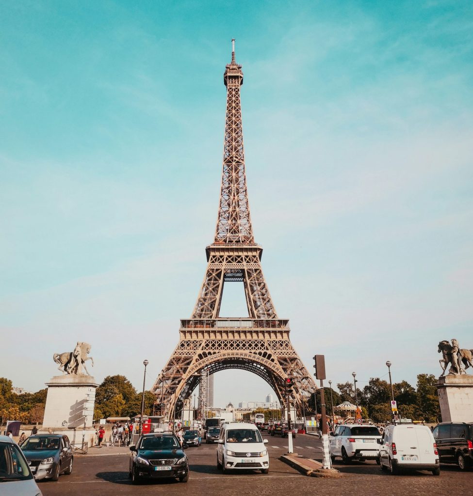 cars travelling on road heading towards Eiffel Tower